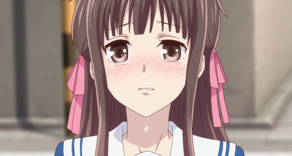 A still frame of Tohru Honda crying, from the 2019 remake of the popular shoujo anime Fruits Basket.